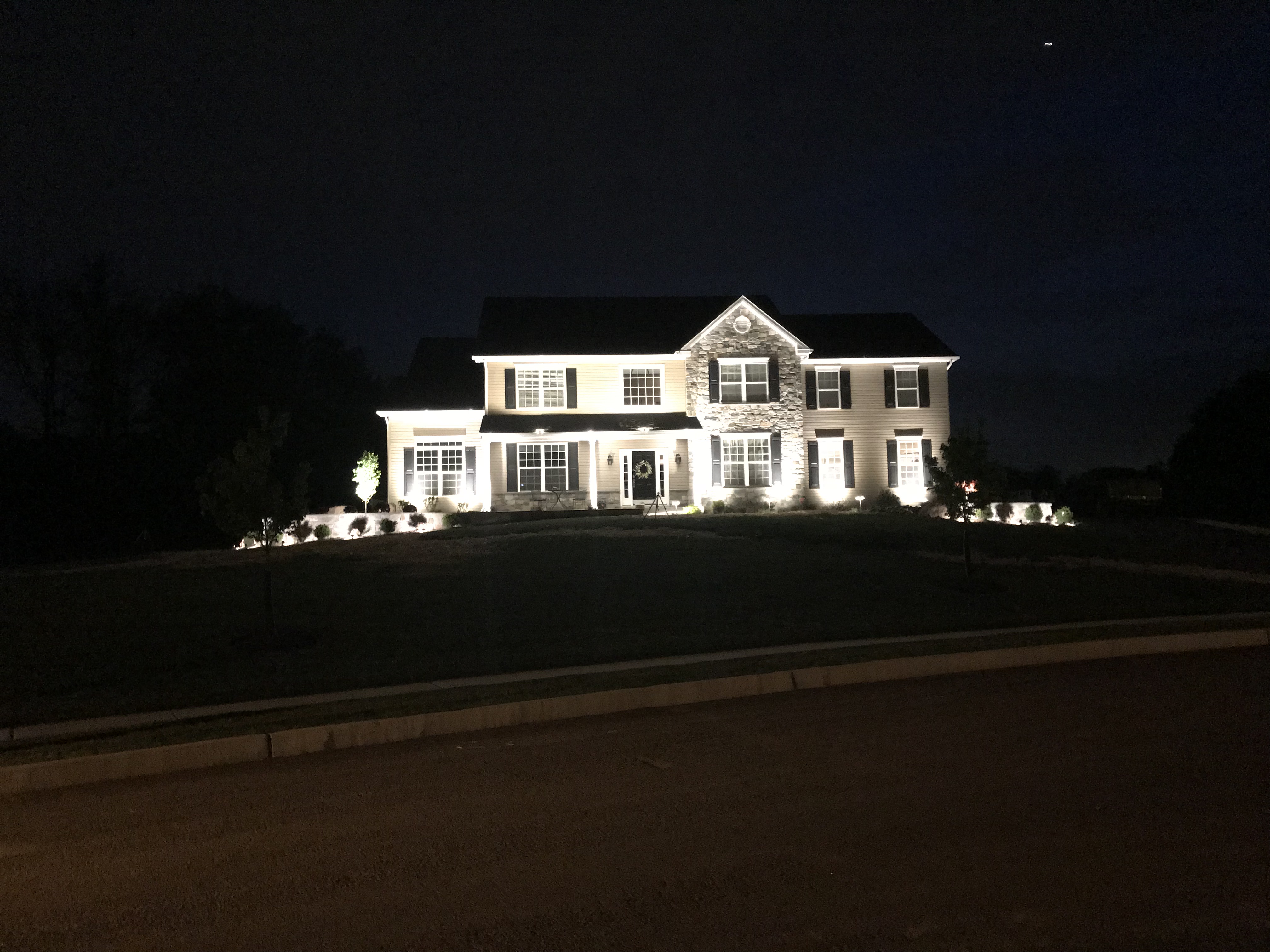 house with landscaping lights at night